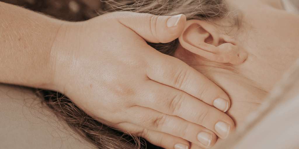 hierojan kädet hieromassa asiakkaan niska-hartia-aluetta klassisessa hieronnassa hoitohuoneessa Porvoossa