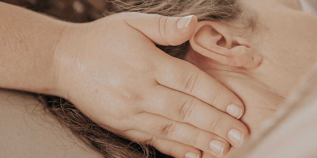 hierojan kädet hieromassa asiakkaan niska-hartia-aluetta klassisessa hieronnassa hoitohuoneessa Porvoossa